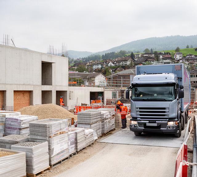 Baustellenfahrzeug bei der Anlieferung von Baustoffen auf einer Schweizer Baustelle