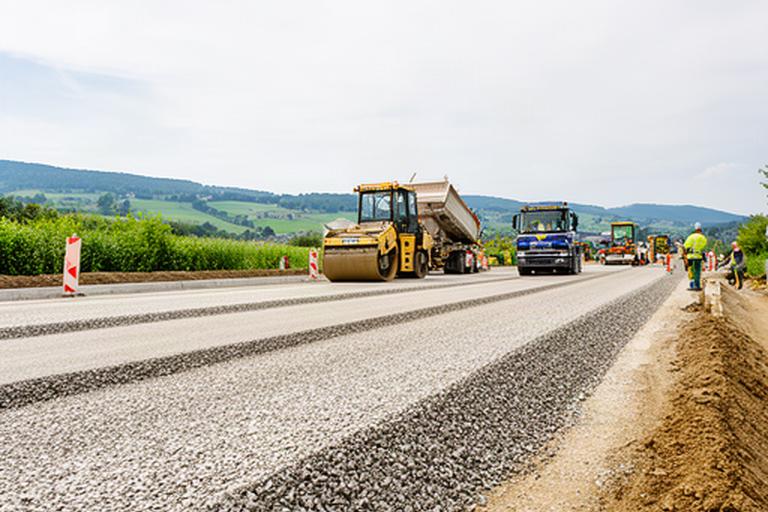 Kantonale Strasse in der Waadt während des Einbaus von Kies und Splitt
